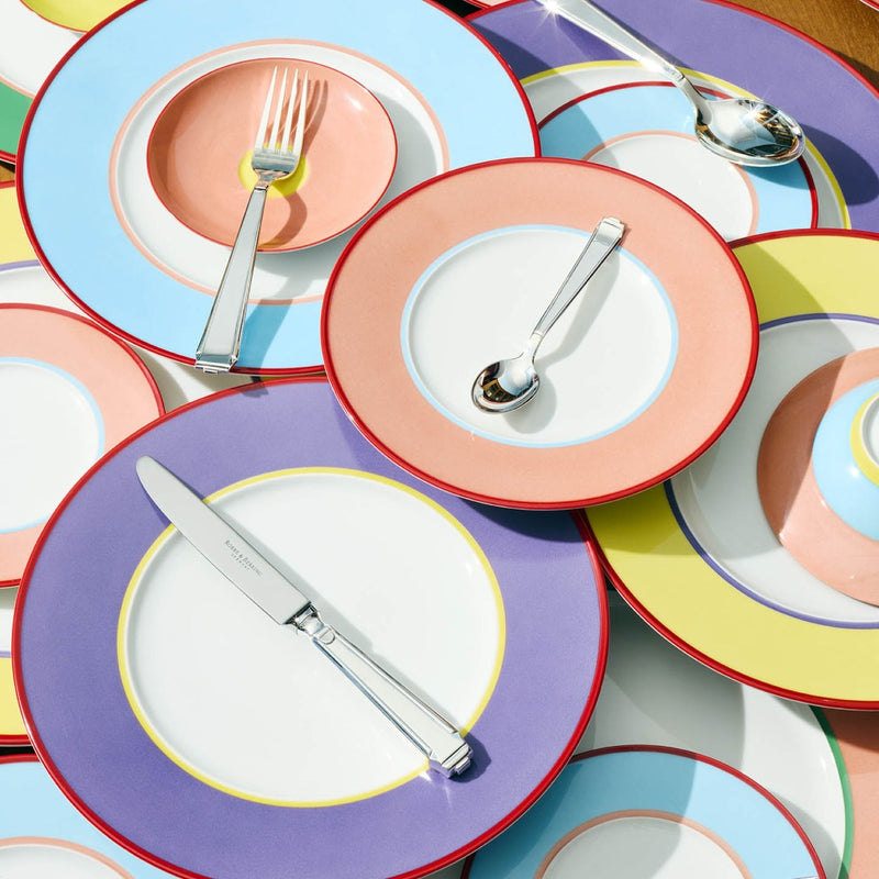 Table fork Art Deco silver-plated with geometric handle displayed on colourful plate next to knife and spoon.