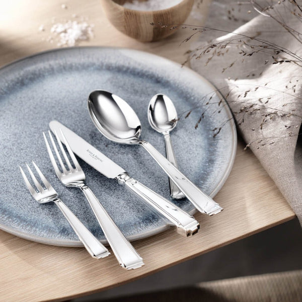 Table knife Art Deco silver-plated with structured handle and defined placed next to fork and spoon on blue plate.