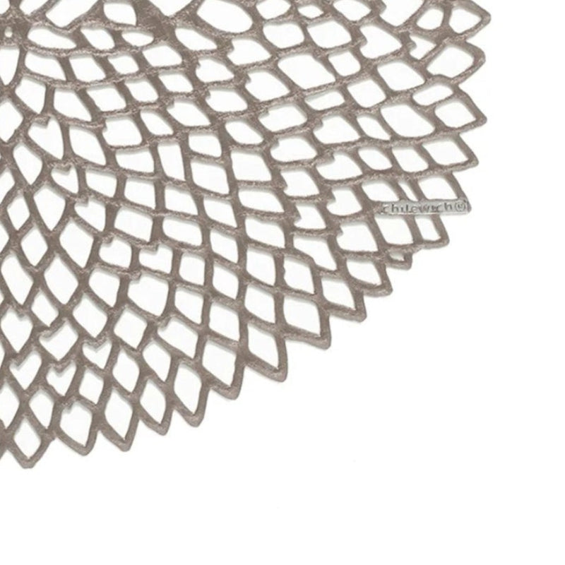 Chilewich Dahlia gunmetal round vinyl placemat with lace-cut detail close-up.