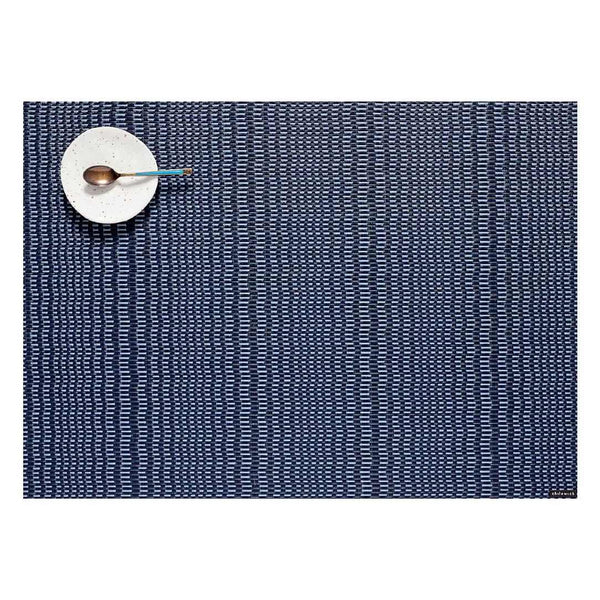 Chilewich Swell placemat in storm blue with wave-like textured pattern.