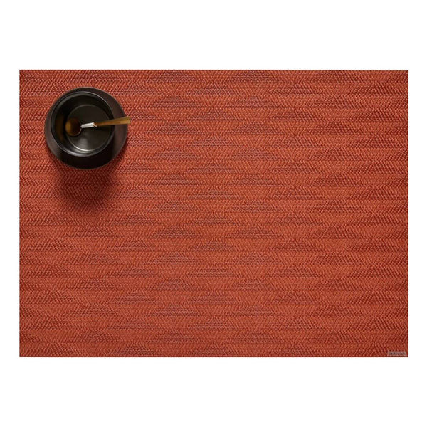 Chilewich Arrow placemat in paprika orange with geometric pattern.