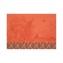 Orange cotton placemat with forest motifs and geometric border by Le Jaquard Francais.