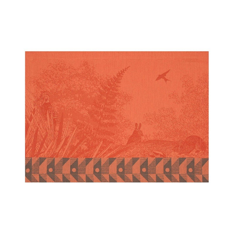 Orange cotton placemat with forest motifs and geometric border by Le Jaquard Francais.