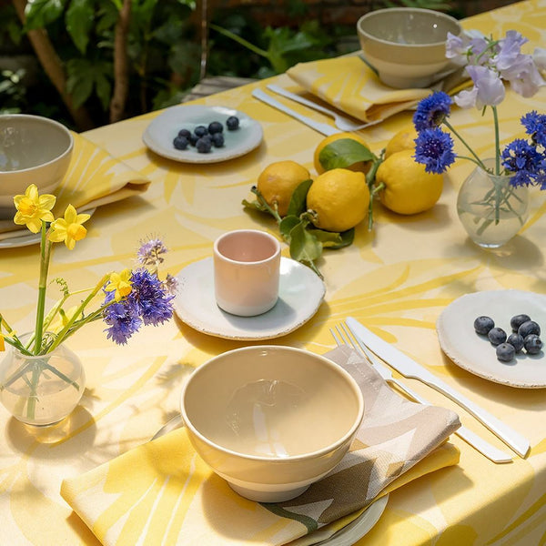 Yellow coated cotton placemat with jacquard daffodil and chevron design with matching tablecloth.