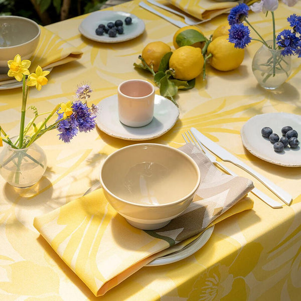 Yellow coated napkin with daffodils and chevron pattern styled with matching tablecloth.