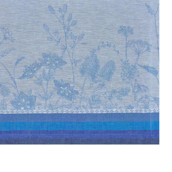Blue linen placemat with jacquard floral motifs in soft tones close-up on texture.