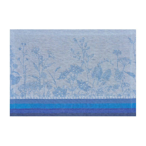 Blue linen placemat with jacquard floral motifs in soft tones by Le Jaquard Francais.
