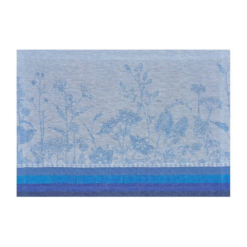 Blue linen placemat with jacquard floral motifs in soft tones by Le Jaquard Francais.