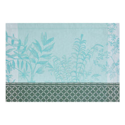 Blue cotton placemat with botanical jacquard ivy and calathea motifs by Le Jaquard Francais.