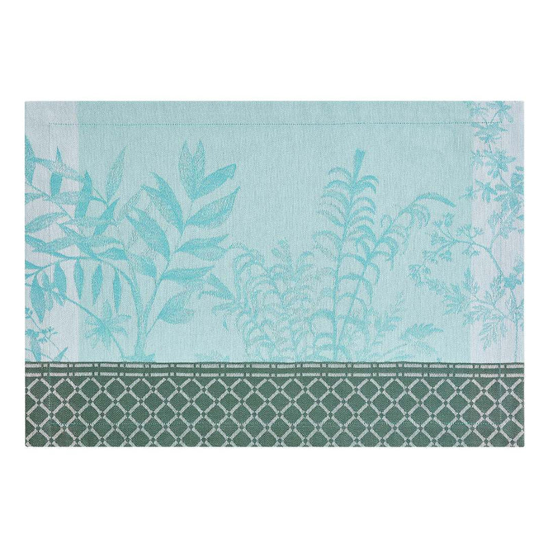 Blue cotton placemat with botanical jacquard ivy and calathea motifs by Le Jaquard Francais.