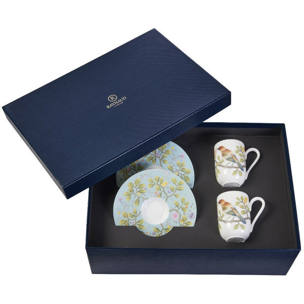 A set of two espresso cups and saucers with turquoise and multicolor floral patterns, presented in a navy blue gift box with the Raynaud brand logo.