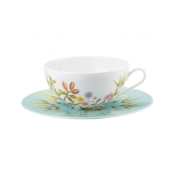 tea cup and saucer in white and turquoise with floral and birds design