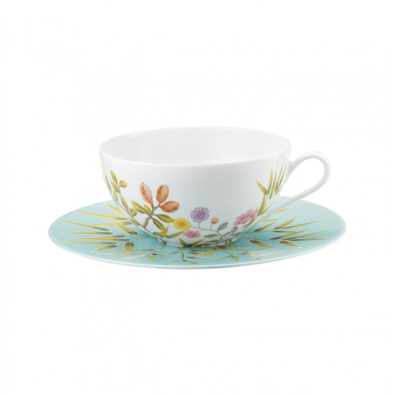 tea cup and saucer in white and turquoise with floral and birds design