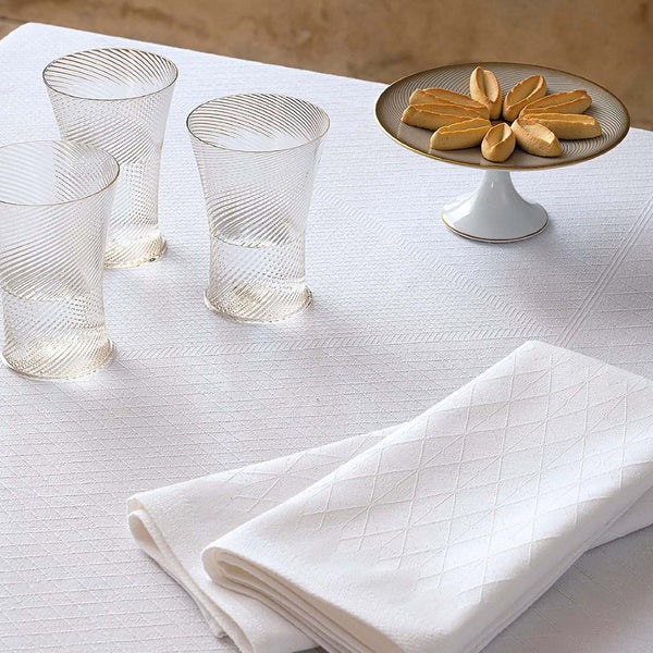 Club Cotton Napkin in White by Le Jacquard Français folded on white tablecloth