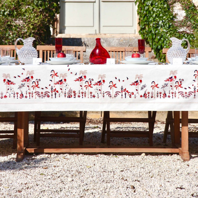 a table with a white tablecloth and red vases on it