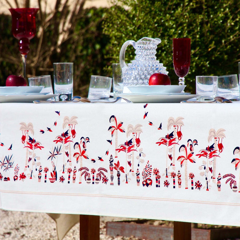 a table with a white tablecloth with glasses and a pitcher on it