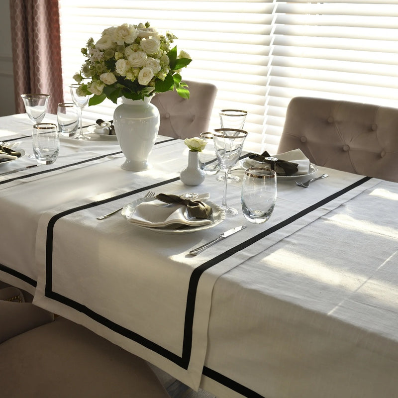 Elegant white tablecloth with black stripe border made from 100% Italian cotton.