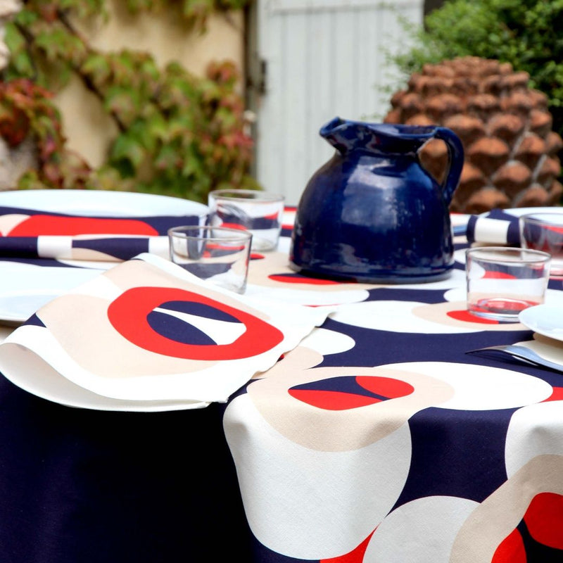 Close-up of  red, blue, and ivory bubble patterns on Alto Duo ecru luxury napkin fabric.