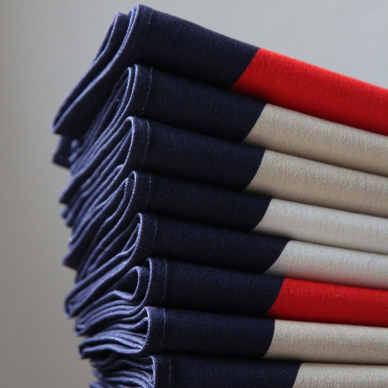 Close-up of stitching of Bubble navy napkin with red, white, and ivory 70s-inspired bubble motifs.