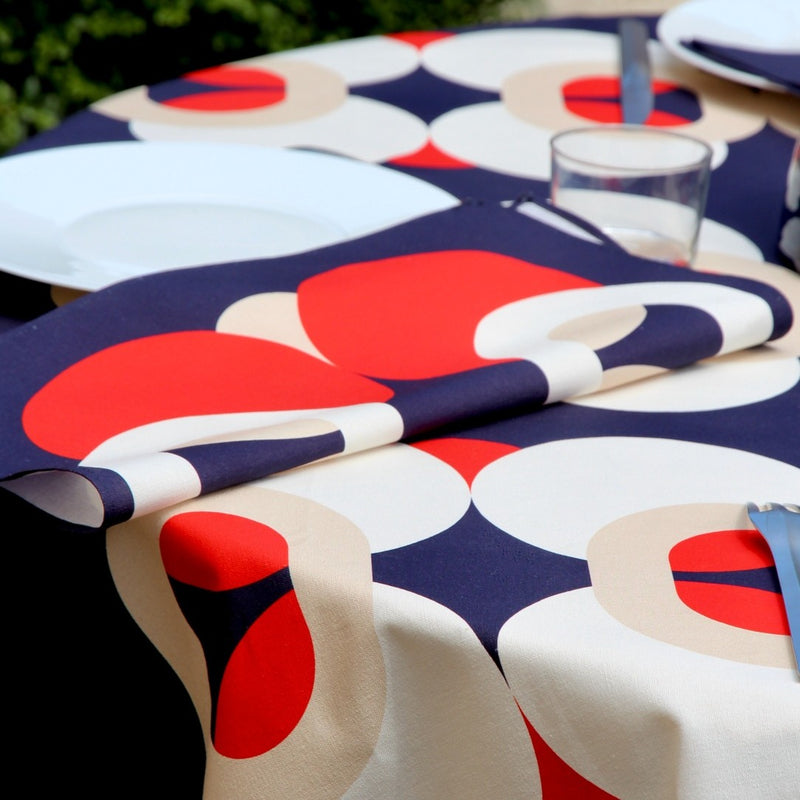 Bubble Navy napkin with vibrant red, white, and ivory 70s-inspired bubble motifs side view on table.