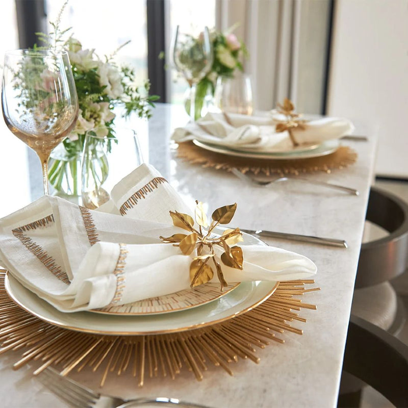 Gold sunburst Radiate charger plate by Kim Seybert styled on luxury tablescape side view.