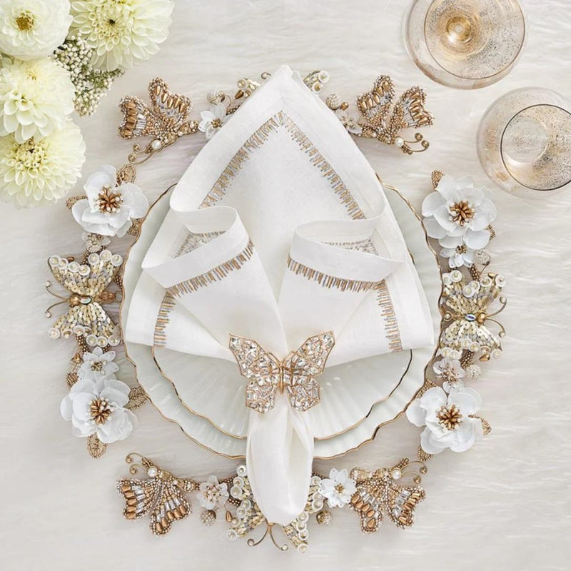 Ivory and gold Papillon charger with hand-beaded butterflies and blossoms styled on floral tablescape.