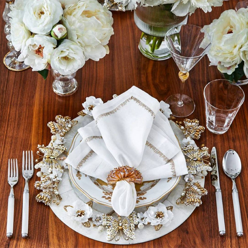 Ivory and gold Papillon charger with hand-beaded butterflies and blossoms on luxury table setting.