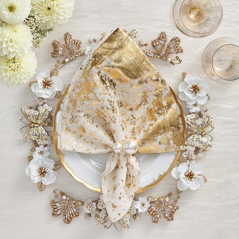 Ivory and gold Papillon charger with hand-beaded butterflies and blossoms styled with gold napkin.