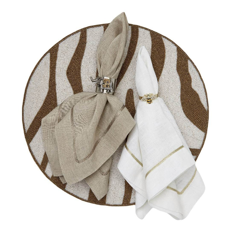 Zebra beaded placemats with brown stripes by Joanna Buchanan styled with taupe and white napkins.