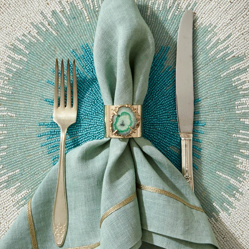 Quartz green napkin rings by Joanna Buchanan styled with a green napkin on beaded placemat.
