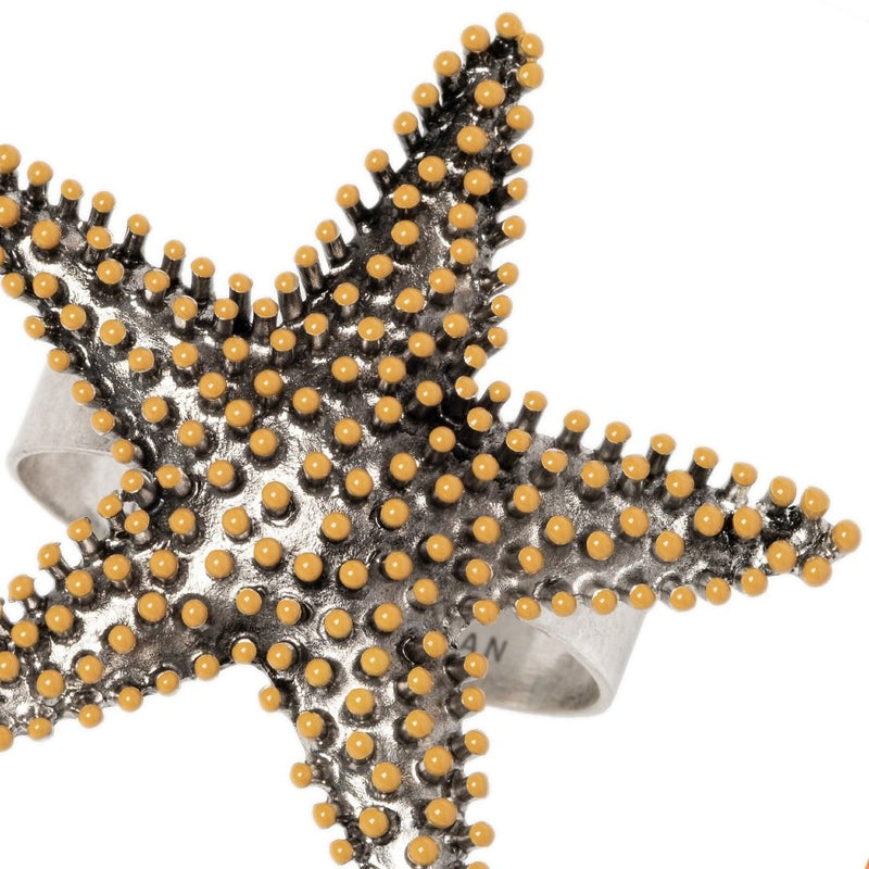 Close-up of starfish napkin ring by Joanna Buchanan, featuring textured metallic finish 