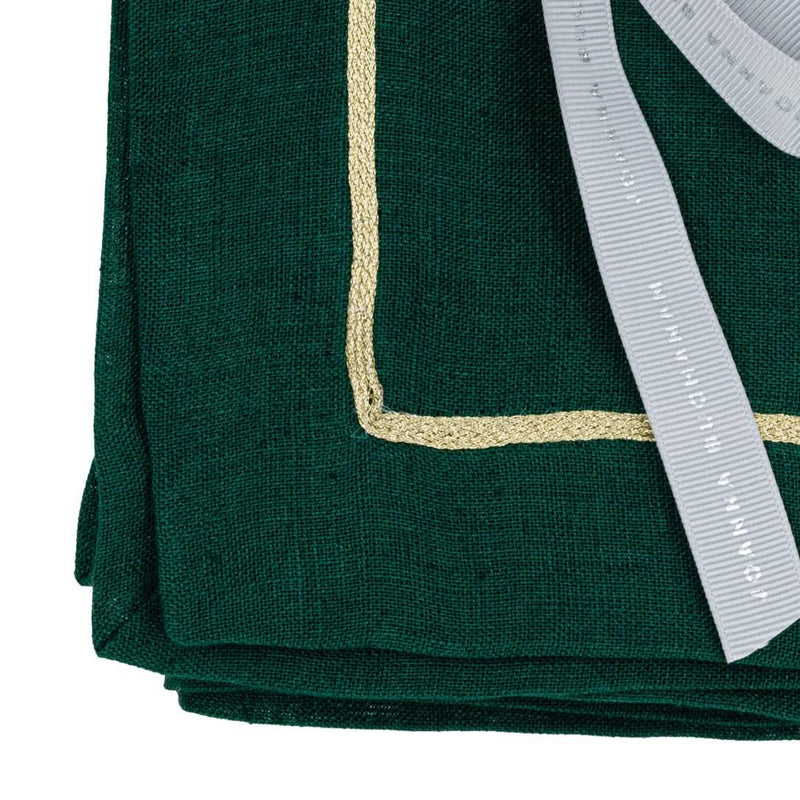 Detail shot of ornate gold edging on hunter green napkin by Joanna Buchanan.