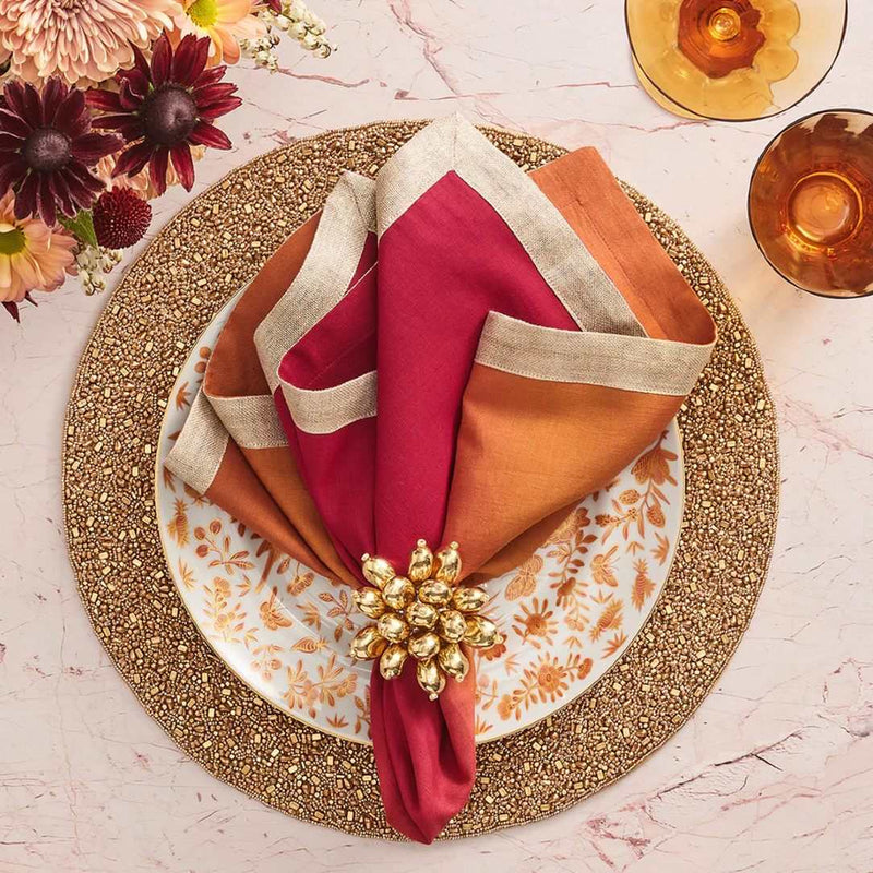 Dip dye napkin in red orange ombre styled  with gold napkin ring.