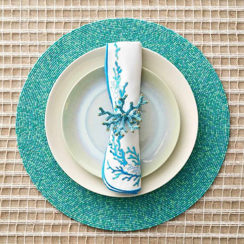 Reef napkin in white with turquoise and gold embroidery, styled with turquoise napkin ring.