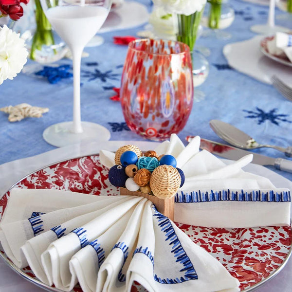 Side view of Filament napkin with rattan napkin ring on colorful table setting by Amiramour