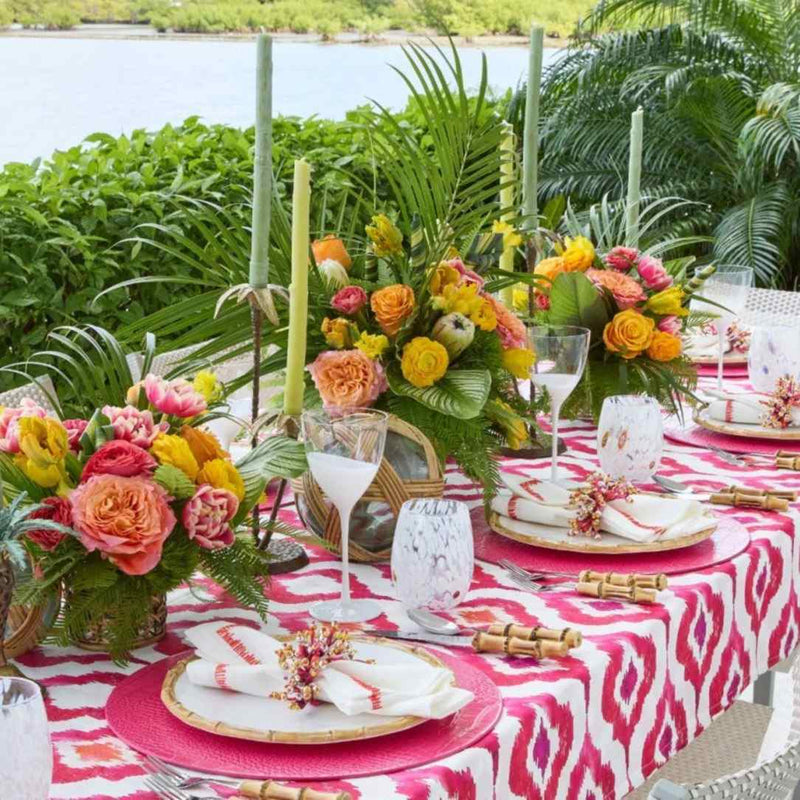 Kim Seybert Filament napkin on a tropical table setting with floral accents, side view 