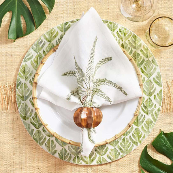 Palm Coast napkin styled on a coastal-inspired table in white and green tones, top view