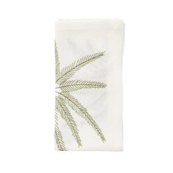 Folded Palm Coast napkin in white linen with gold and green palm embroidery by Kim Seybert, shown at Amiramour