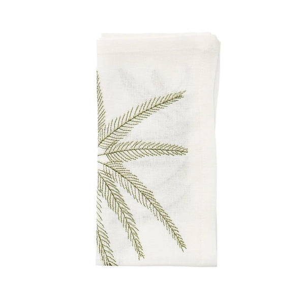 Folded Palm Coast napkin in white linen with gold and green palm embroidery by Kim Seybert, shown at Amiramour