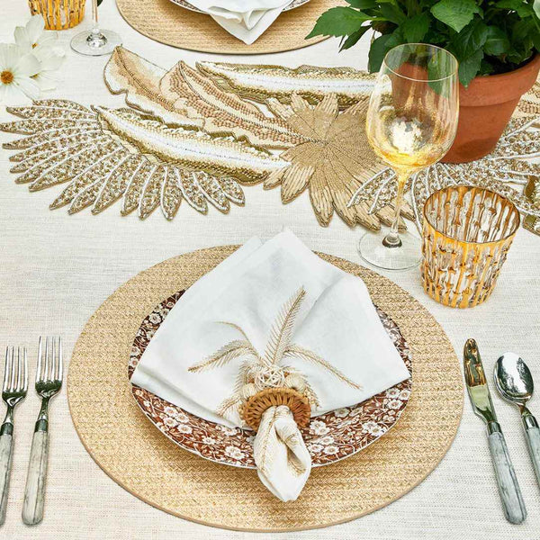 Kim Seybert Palm Coast napkin on a refined seaside table with soft gold and beige accents