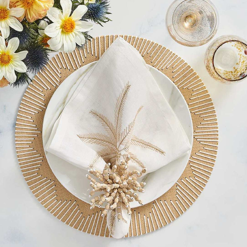 Palm Coast napkin styled on a coastal-inspired table in white and natural tones, top view