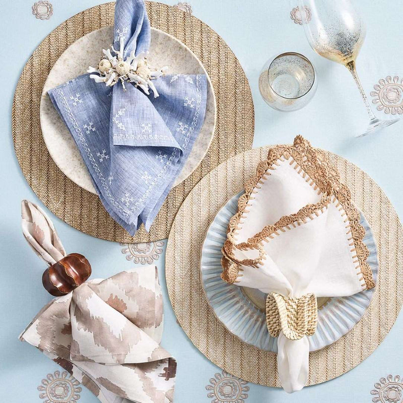 Styled Fez napkin with white embroidery presented next to casual coastal napkins and napkin rings