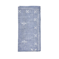 Folded Fez linen napkin in blue with white embroidered Moroccan motifs by Kim Seybert, sold at Amiramour