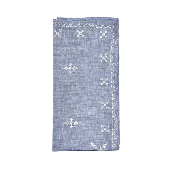 Folded Fez linen napkin in blue with white embroidered Moroccan motifs by Kim Seybert, sold at Amiramour