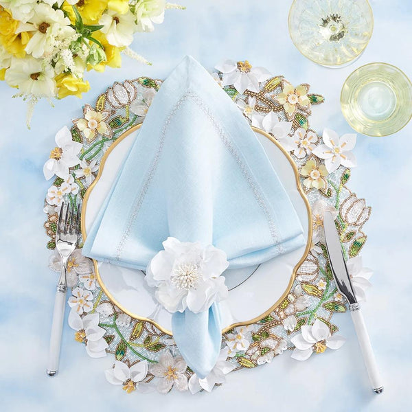 Sky blue clasic napkin by Kim Seybert styled on a floral table setting, top view, sold by Amiramour