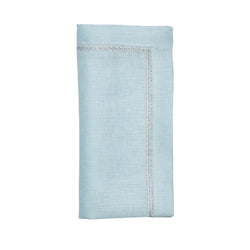 Folded sky blue linen napkin with embroidered star border on white background, sold at Amiramour