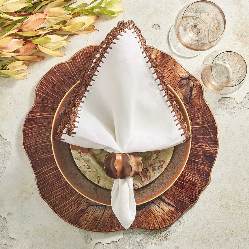 Shell Edge Napkin by Kim Seybert styled on wood placemat, top view, available at Amiramour