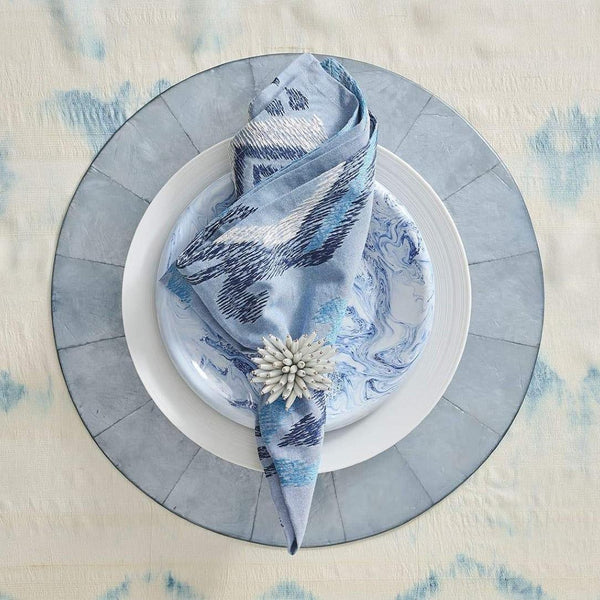 Styled Blue Marrakesh cotton napkin by Kim Seybert on blue capiz placemat, sold at Amiramour.