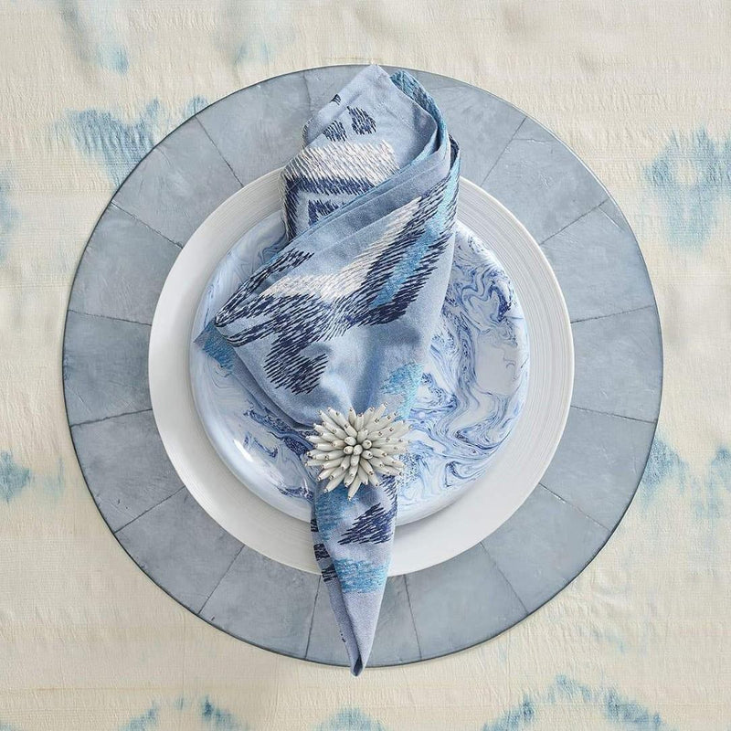 Styled Blue Marrakesh cotton napkin by Kim Seybert on blue capiz placemat, sold at Amiramour.