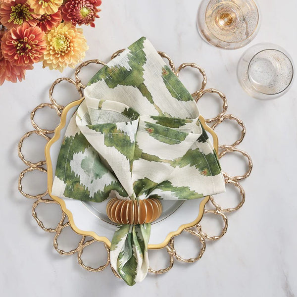 Olive green Watercolor Ikat napkin by Kim Seybert, styled on gold plate charger, sold at Amiramour.